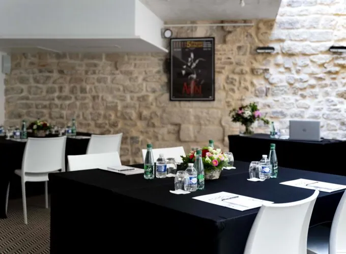 Une salle de conférence avec des tables, des chaises et une affiche accrochée au mur