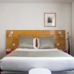 Chambre Double avec un lit et un tableau au mur au-dessus du lit à l’Hôtel Lorette