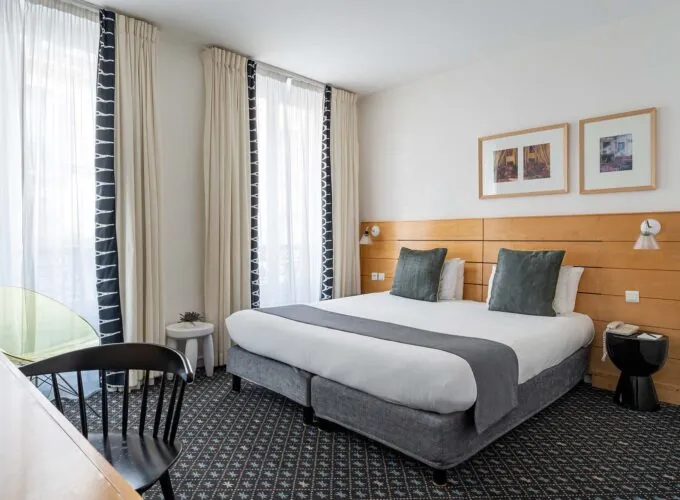 Chambre Double Supérieure avec un grand lit et une chaise à l’Hôtel Lorette