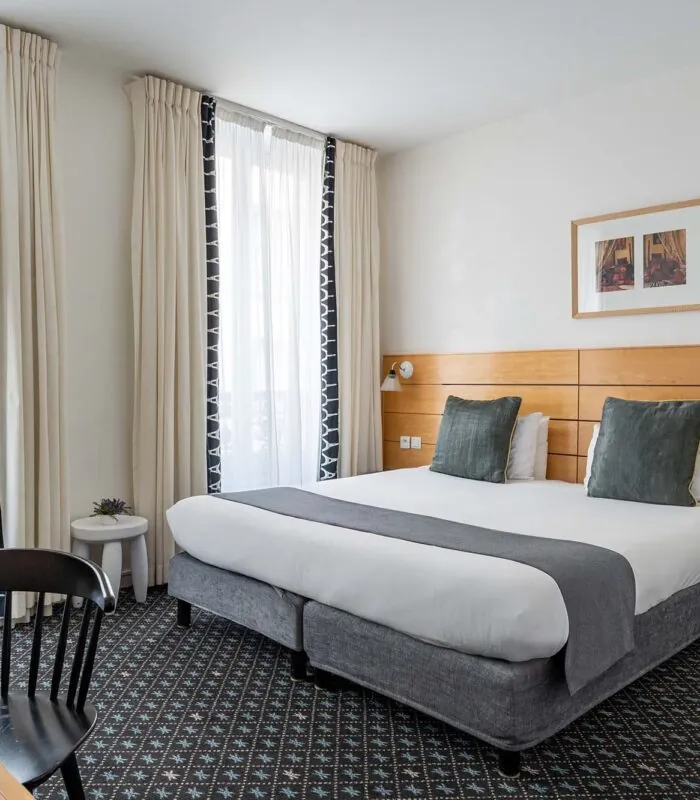 Chambre Double Supérieure avec un grand lit et une chaise à l’Hôtel Lorette