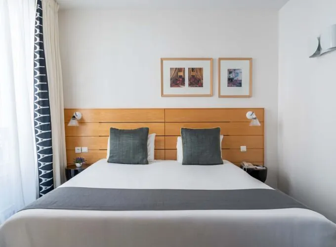 Chambre Double Supérieure avec un lit et deux tableaux au mur à l’Hôtel Lorette