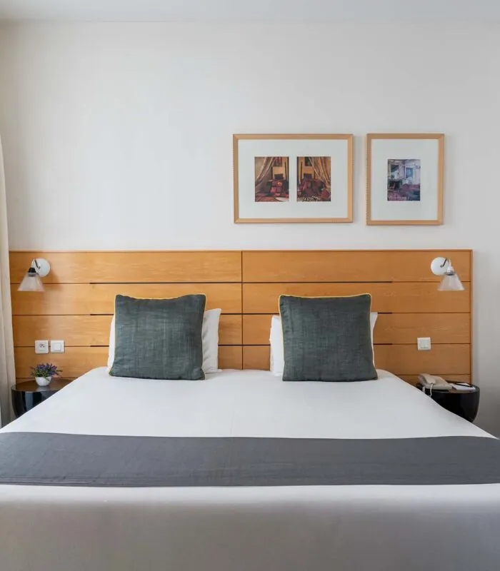 Chambre Double Supérieure avec un lit et deux tableaux au mur à l’Hôtel Lorette