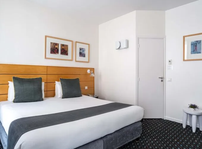 Chambre Double Supérieure avec un lit et trois tableaux au mur à l’Hôtel Lorette