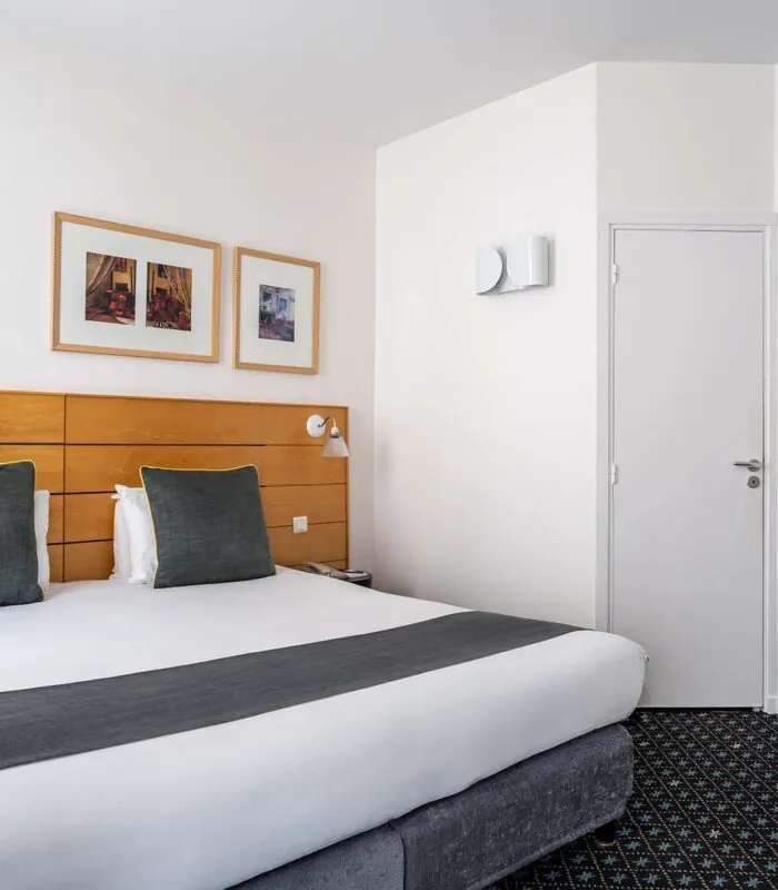 Chambre Double Supérieure avec un lit et trois tableaux au mur à l’Hôtel Lorette