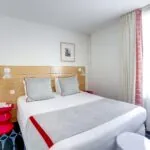 Chambre Familiale avec un lit et un tableau au mur à l’Hôtel Lorette