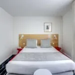 Chambre Familiale avec un lit et un tableau au mur à l’Hôtel Lorette