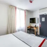 Chambre Familiale avec un lit, un bureau et une télévision à l’Hôtel Lorette