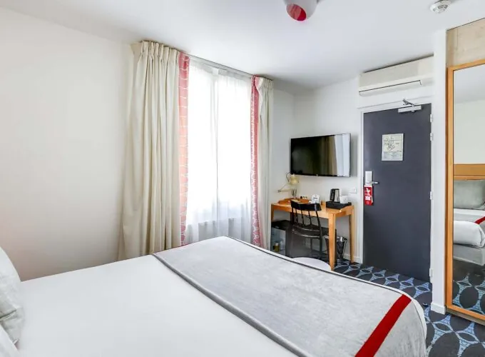 Chambre Familiale avec un lit, un bureau et une télévision à l’Hôtel Lorette