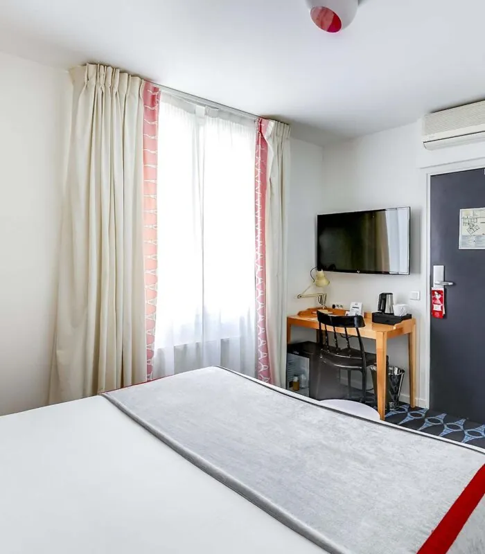Chambre Familiale avec un lit, un bureau et une télévision à l’Hôtel Lorette