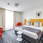 Chambre Familiale Supérieure avec deux lits et un bureau à l’Hôtel Lorette