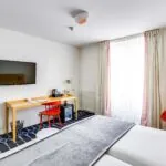 Chambre Familiale Supérieure avec un bureau et une télévision à écran plat à l’Hôtel Lorette