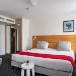 Chambre Privilège avec un lit et un tableau au mur à l’Hôtel Lorette