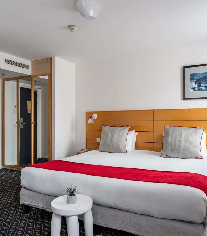 Chambre Privilège avec un lit et un tableau au mur à l’Hôtel Lorette