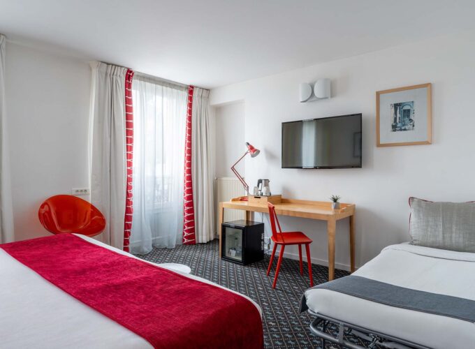 Chambre Privilège avec un lit, un bureau et une télévision à écran plat à l’Hôtel Lorette