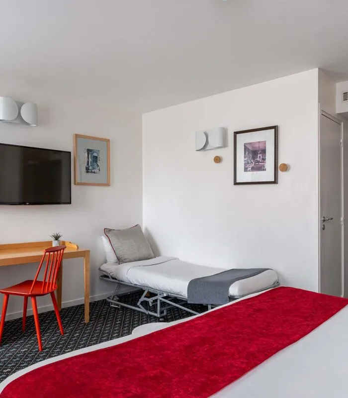 Chambre Privilège avec un lit, un bureau et une télévision à écran plat à l’Hôtel Lorette