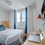Chambre Single avec un lit et un bureau avec un ordinateur portable dessus à l’Hôtel Lorette