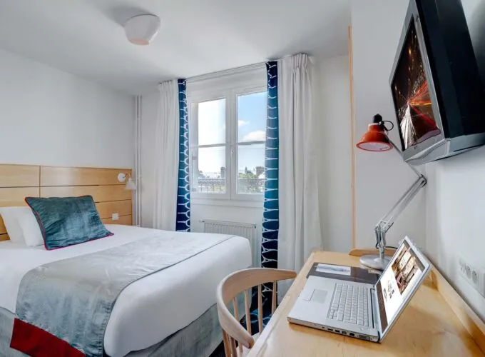 Chambre Single avec un lit et un bureau avec un ordinateur portable dessus à l’Hôtel Lorette