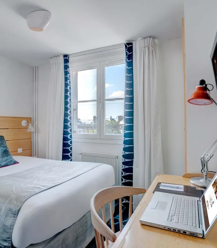 Chambre Single avec un lit et un bureau avec un ordinateur portable dessus à l’Hôtel Lorette