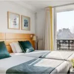 Chambre Twin avec deux lits et une fenêtre ouverte à l’Hôtel Lorette