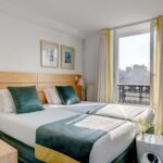 Chambre Twin avec deux lits et une fenêtre à l’Hôtel Lorette