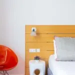 Chambre Twin Supérieure avec une chaise orange et une table blanche à l’Hôtel Lorette