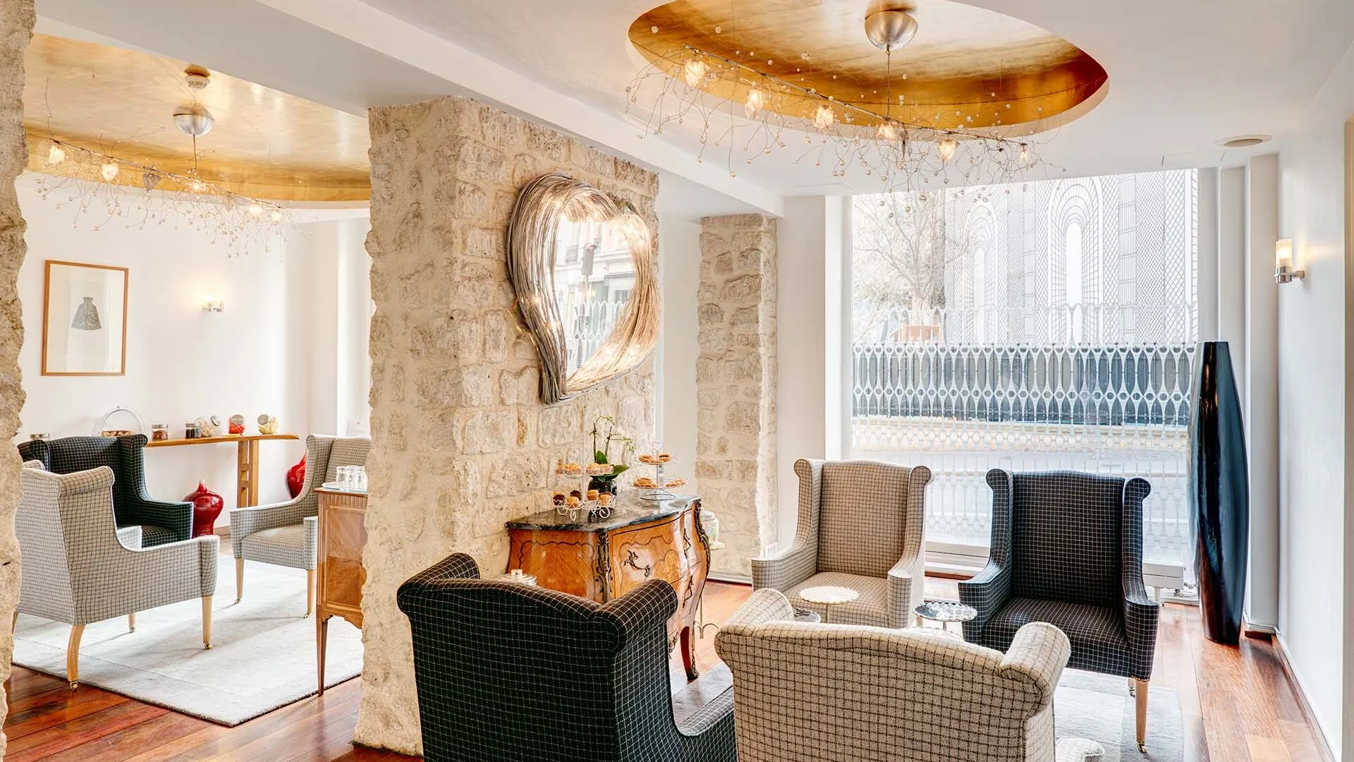Vue du lobby de l’Hôtel 3 étoiles Lorette à Paris, où l’élégance des couleurs se marie harmonieusement avec le charme des murs en pierre historiques, créant une atmosphère raffinée
