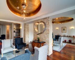 Lobby de l’Hôtel 3 étoiles Lorette à Paris avec des couleurs élégantes, des murs en pierre historiques et une atmosphère raffinée