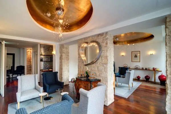 Lobby de l’Hôtel 3 étoiles Lorette à Paris avec des couleurs élégantes, des murs en pierre historiques et une atmosphère raffinée