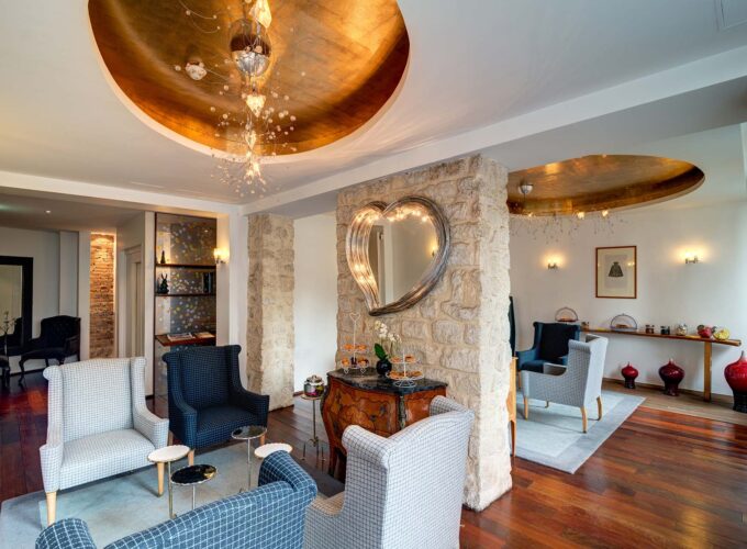 Lobby de l’Hôtel 3 étoiles Lorette à Paris avec des couleurs élégantes, des murs en pierre historiques et une atmosphère raffinée