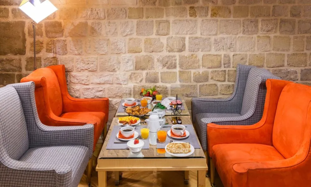 Vue de la salle de petit-déjeuner de l’Hôtel Lorette, un espace accueillant où les clients peuvent profiter d’un buffet varié. L’atmosphère y est chaleureuse et animée