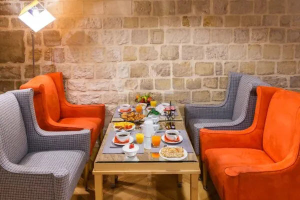 Vue de la salle de petit-déjeuner de l’Hôtel Lorette, un espace accueillant où les clients peuvent profiter d’un buffet varié. L’atmosphère y est chaleureuse et animée