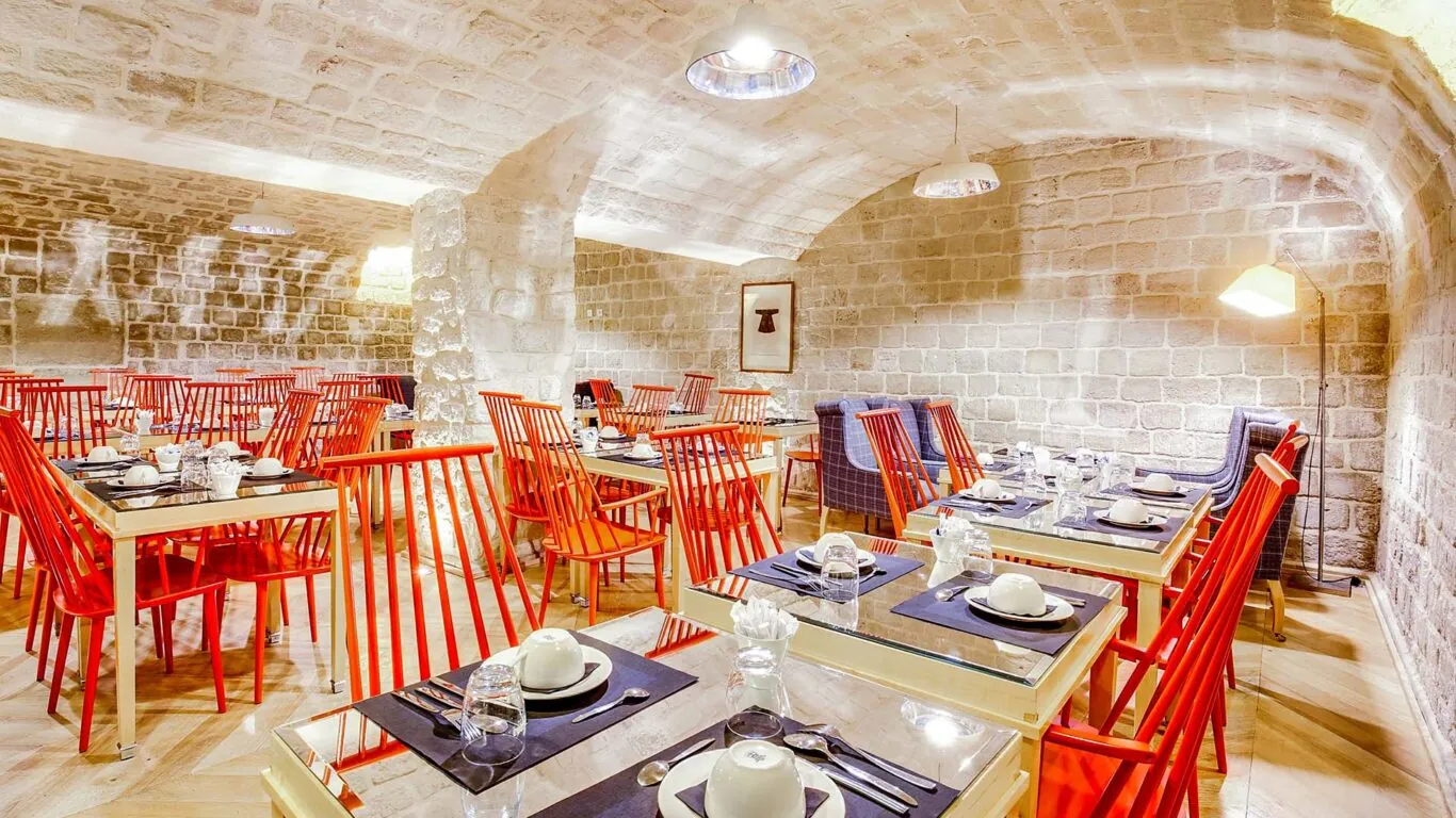 Vue de la salle de petit-déjeuner de l’Hôtel Lorette, un espace accueillant où les clients peuvent profiter d’un buffet varié. L’atmosphère y est chaleureuse et animée