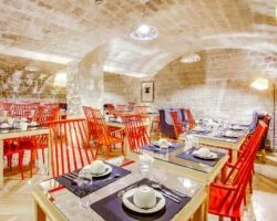 Vue de la salle de petit-déjeuner de l’Hôtel Lorette, un espace accueillant où les clients peuvent profiter d’un buffet varié. L’atmosphère y est chaleureuse et animée