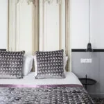 Lit d’une chambre Double avec des oreillers noirs et blancs à l’Hôtel Malte