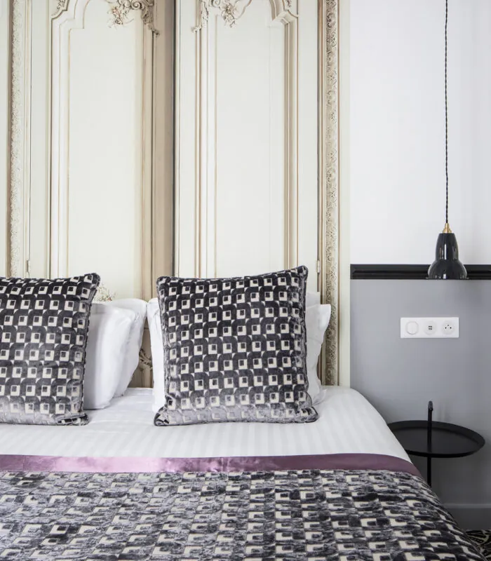 Lit d’une chambre Double avec des oreillers noirs et blancs à l’Hôtel Malte