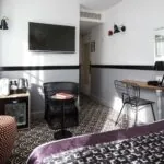 Chambre Double Supérieure avec une chaise et une télévision au mur à l’Hôtel Malte