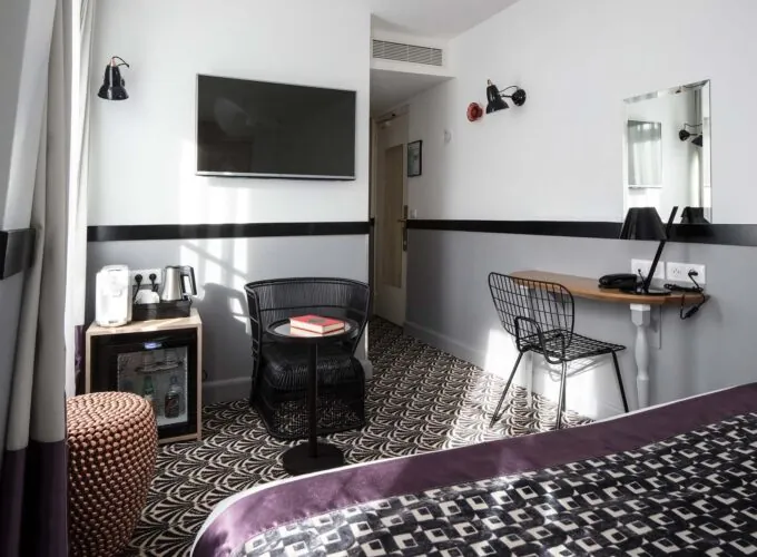 Chambre Double Supérieure avec une chaise et une télévision au mur à l’Hôtel Malte