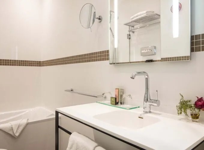 Salle de bain d’une chambre Double Supérieure avec un lavabo, un miroir et une baignoire à l’Hôtel Malte