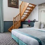 Chambre Duplex avec un escalier en bois menant à l’étage supérieur à l’Hôtel Malte