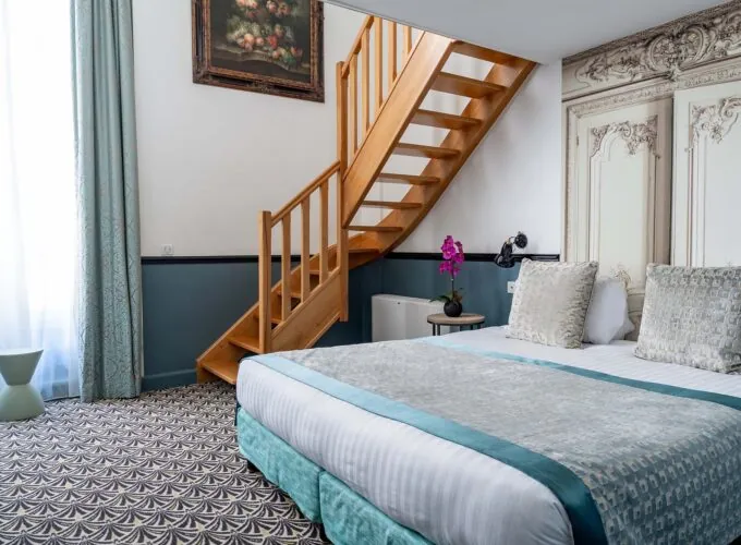 Chambre Duplex avec un escalier en bois menant à l’étage supérieur à l’Hôtel Malte