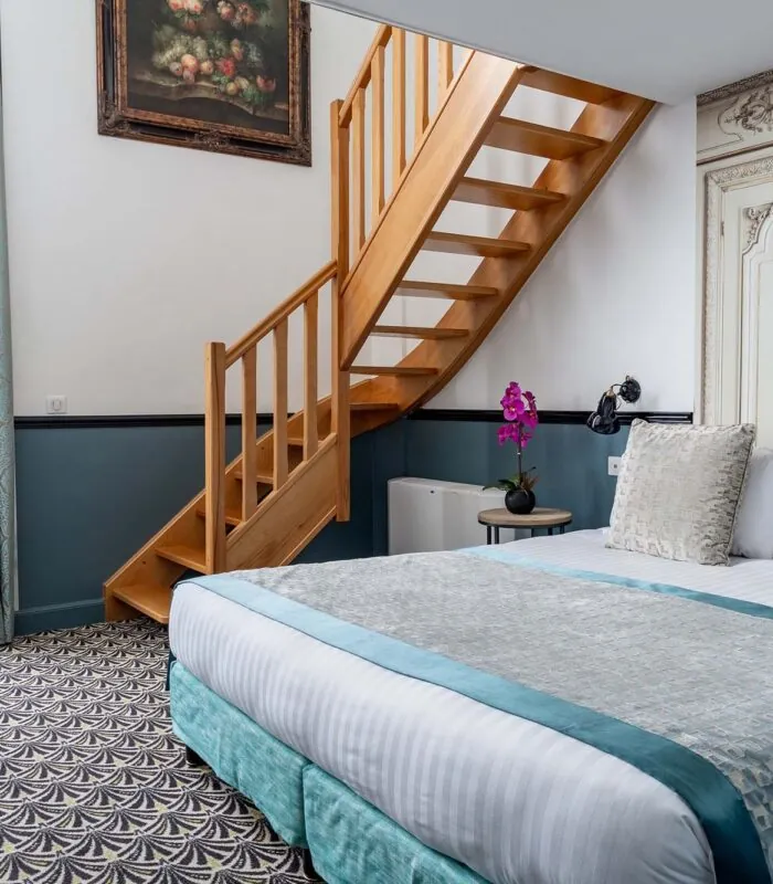 Chambre Duplex avec un escalier en bois menant à l’étage supérieur à l’Hôtel Malte