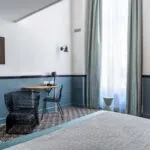 Chambre Duplex avec un lit, une chaise, une table et une télévision à écran plat à l’Hôtel Malte