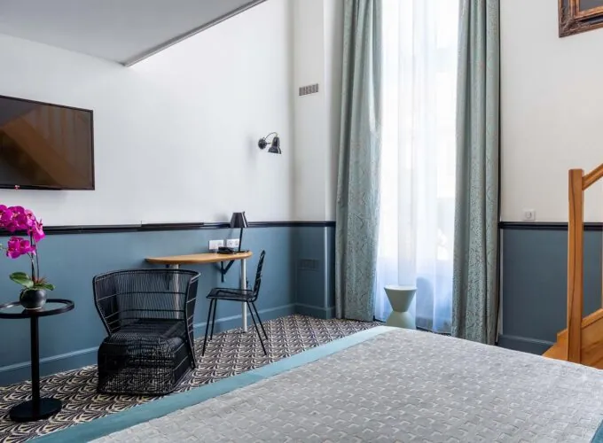 Chambre Duplex avec un lit, une chaise, une table et une télévision à écran plat à l’Hôtel Malte