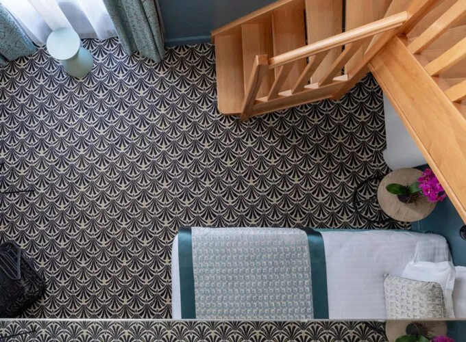 Vue en hauteur d’une chambre Duplex avec un lit et des escaliers à l’Hôtel Malte