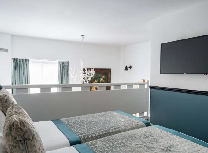 Chambre Duplex avec deux lits et une télévision à écran plat à l’Hôtel Malte
