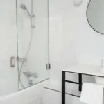 Salle de bain Duplex avec un miroir rond et une baignoire à l’Hôtel Malte
