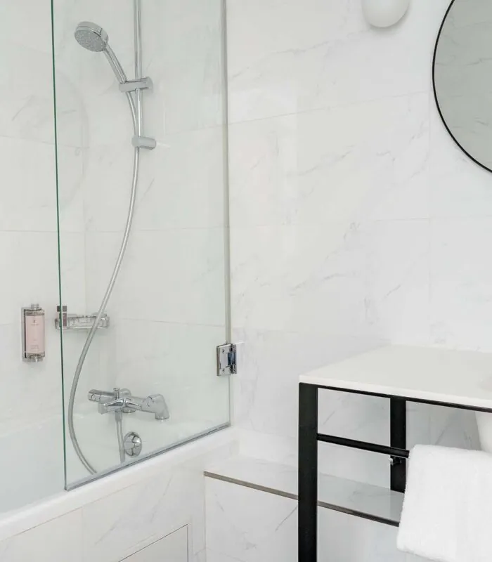 Salle de bain Duplex avec un miroir rond et une baignoire à l’Hôtel Malte