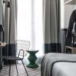 Veste en cuir noire accrochée à un portemanteau dans une chambre Single à l’Hôtel Malte