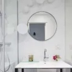 Salle de bain d’une chambre Single avec deux miroirs ronds et un lavabo à l’Hôtel Malte