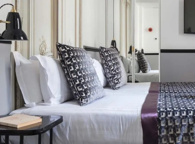 Lit d’une chambre Twin avec des draps blancs et des oreillers noirs et blancs à l’Hôtel Malte